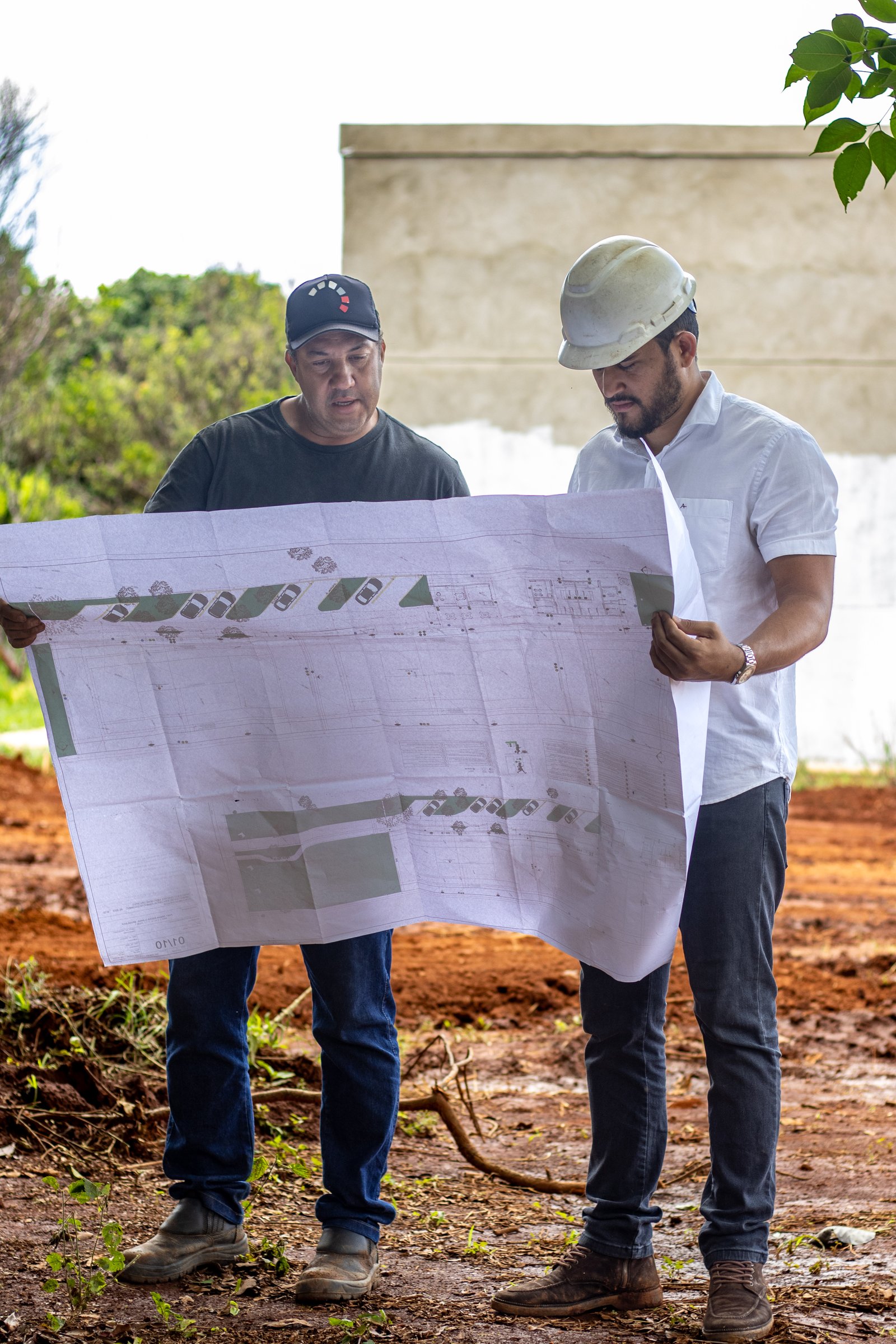 Eng. Yure Zargon analisando planta em terreno de obra