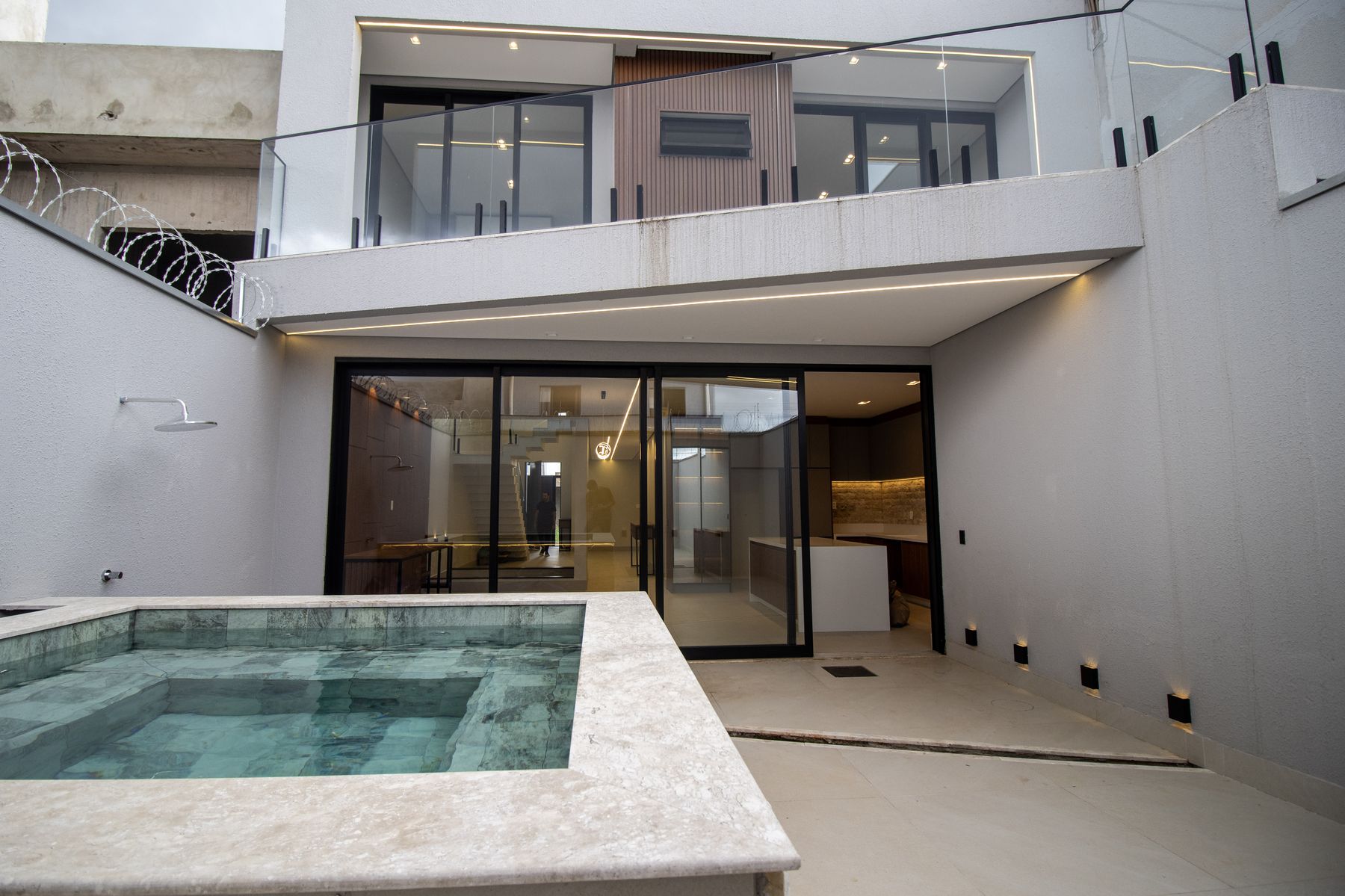 Piscina e spa integrados à área social da casa