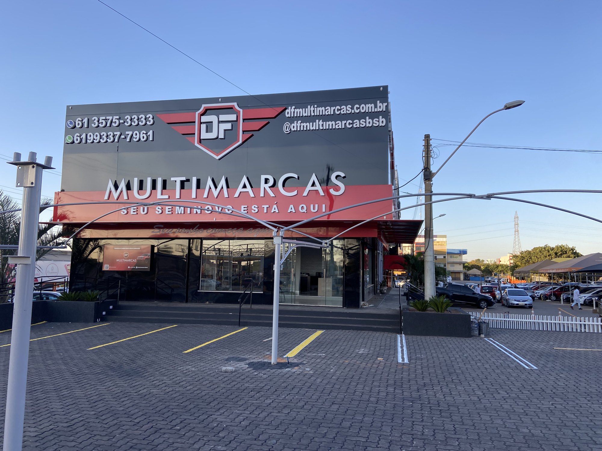Vista lateral da fachada da DF Multimarcas com estacionamento