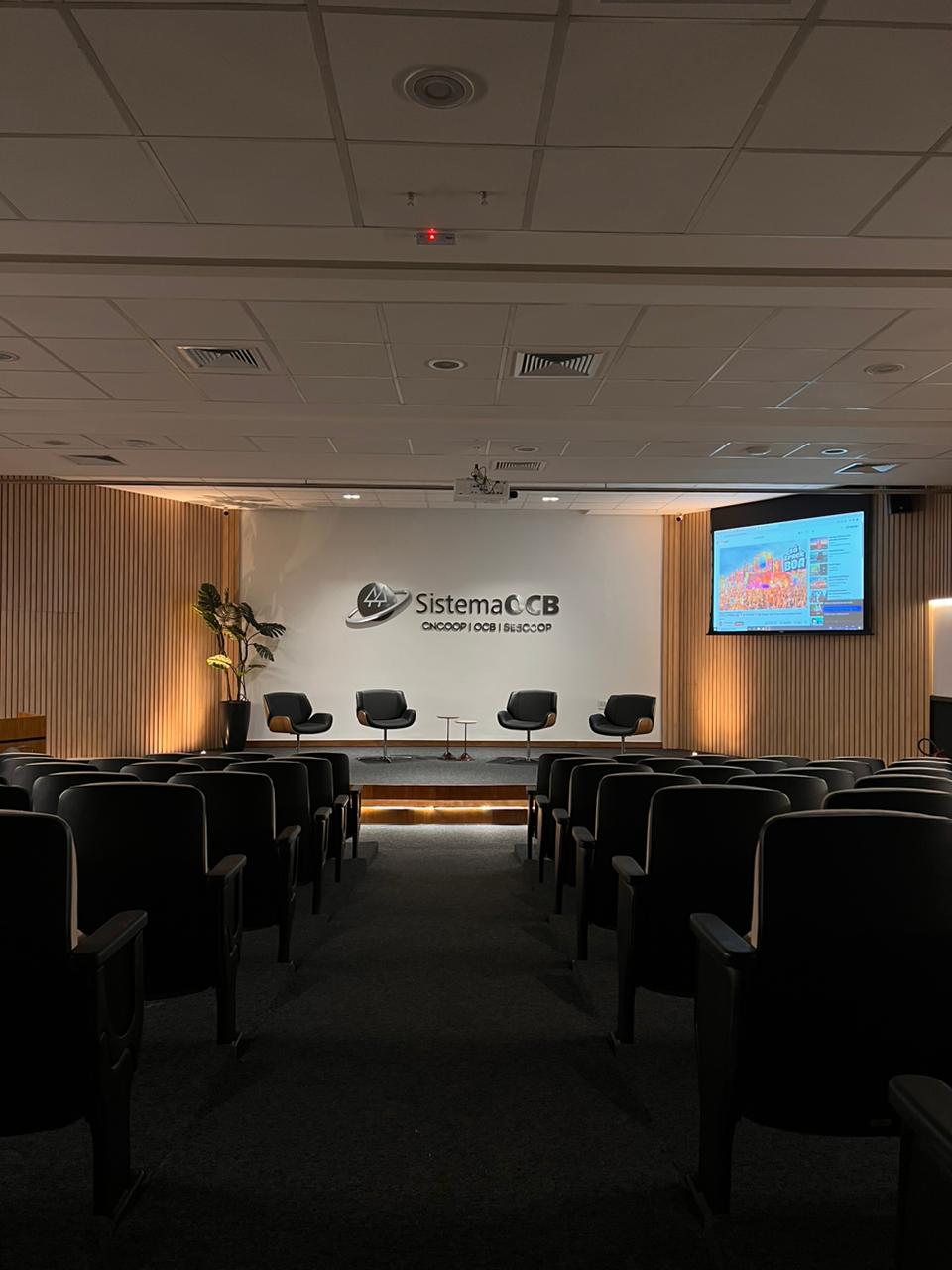 Palco do auditório com identidade visual do Sistema OCB